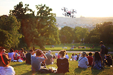Drone flying above crowded park