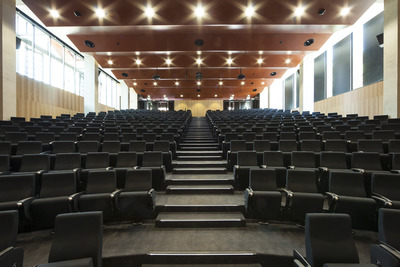 A view of one of the Braggs lecture theatre from the lecturer's standpoint. Bright lights shine onto hundreds of empty seats.